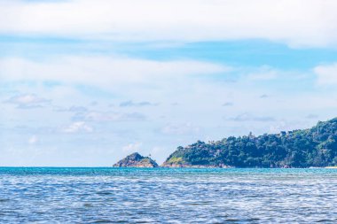 Patong Beach bay sea coast panorama view with turquoise blue clear water waves white sand and green mountains and palm trees in Patong Beach Kathu District Phuket Island Province Southern Thailand.