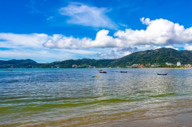 Kathu Phuket Thailand 13. October 2025 Patong Beach bay sea coast panorama view with promenade tourists people turquoise blue water boats mountains and palm trees in Patong Phuket Thailand.