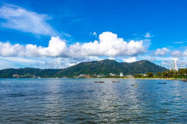Kathu Phuket Thailand 13. October 2025 Patong Beach bay sea coast panorama view with promenade tourists people turquoise blue water boats mountains and palm trees in Patong Phuket Thailand.