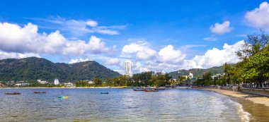 Kathu Phuket Thailand 13. October 2025 Patong Beach bay sea coast panorama view with promenade tourists people turquoise blue water boats mountains and palm trees in Patong Phuket Thailand.