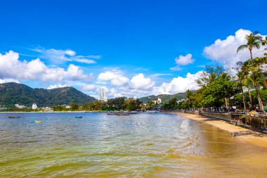 Kathu Phuket Thailand 13. October 2025 Patong Beach bay sea coast panorama view with promenade tourists people turquoise blue water boats mountains and palm trees in Patong Phuket Thailand.