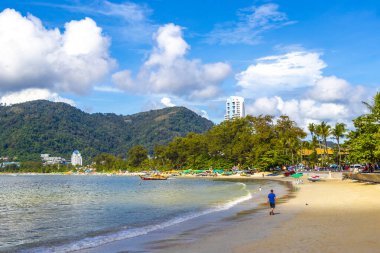 Kathu Phuket Thailand 13. October 2025 Patong Beach bay sea coast panorama view with promenade tourists people turquoise blue water boats mountains and palm trees in Patong Phuket Thailand.