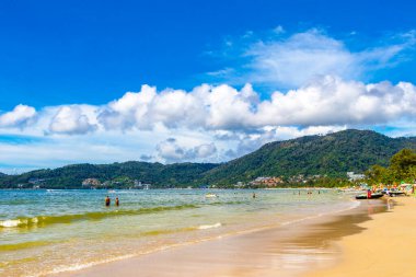 Kathu Phuket Thailand 13. October 2025 Patong Beach bay sea coast panorama view with promenade tourists people turquoise blue water boats mountains and palm trees in Patong Phuket Thailand.
