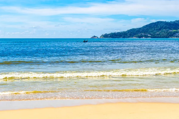 Patong Beach bay sea coast panorama view with turquoise blue clear water waves white sand and green mountains and palm trees in Patong Beach Kathu District Phuket Island Province Southern Thailand.