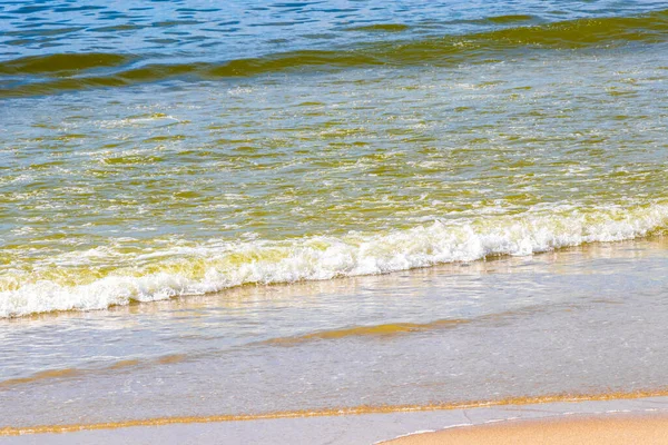 Waves turquoise blue water and sand at tropical beach and sea in Patong Beach Kathu District Phuket Island Province Southern Thailand in Southeast Asia.