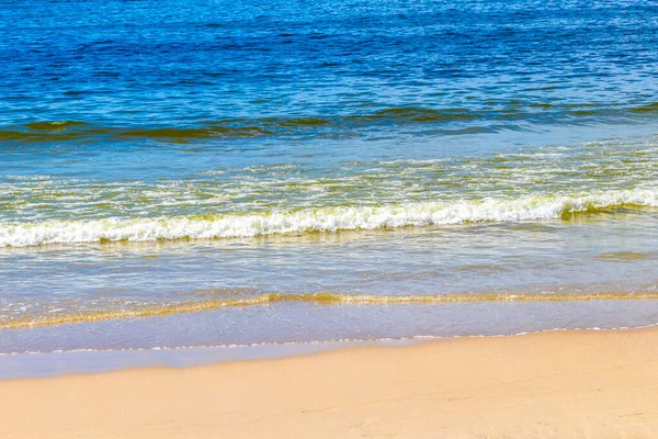 Waves turquoise blue water and sand at tropical beach and sea in Patong Beach Kathu District Phuket Island Province Southern Thailand in Southeast Asia.