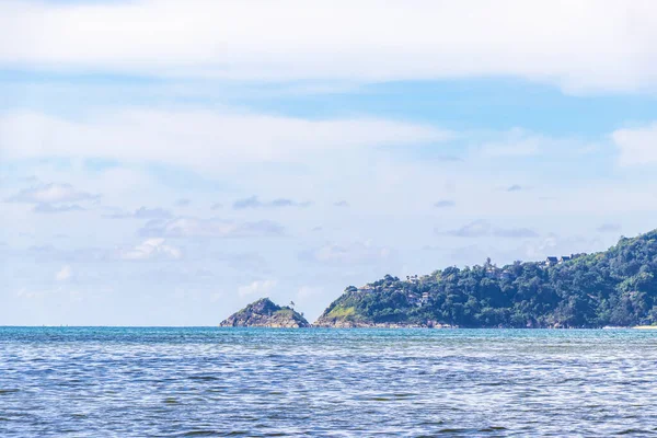 Patong Beach bay sea coast panorama view with turquoise blue clear water waves white sand and green mountains and palm trees in Patong Beach Kathu District Phuket Island Province Southern Thailand.