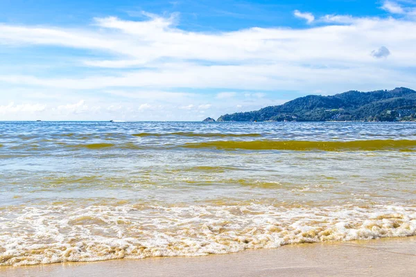 Waves turquoise blue water and sand at tropical beach and sea in Patong Beach Kathu District Phuket Island Province Southern Thailand in Southeast Asia.