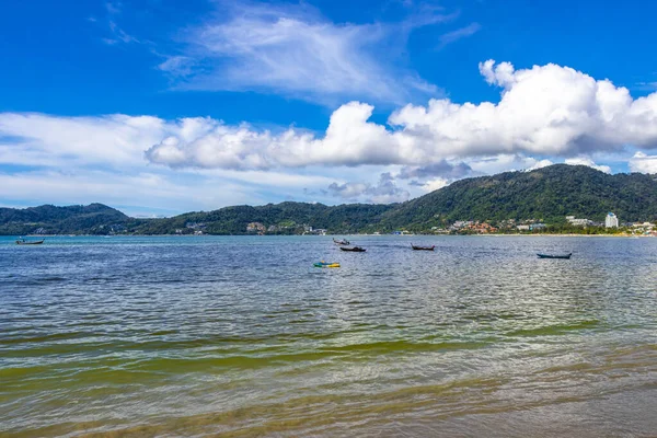Kathu Phuket Thailand 13. October 2025 Patong Beach bay sea coast panorama view with promenade tourists people turquoise blue water boats mountains and palm trees in Patong Phuket Thailand.
