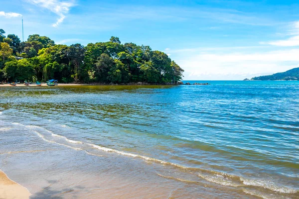 Patong Beach bay sea coast panorama view with turquoise blue clear water waves white sand and green mountains and palm trees in Patong Beach Kathu District Phuket Island Province Southern Thailand.
