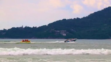 Kathu Phuket Tayland 17 numara. Ekim 2025 'te hız teknesi turistleri muz teknesiyle Patong Sahili Phuket Adası' ndaki Phuket Adası 'nın güney Tayland sahilinde turkuvaz mavisi suya çekiyor..