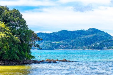 Kathu Phuket Thailand 13. October 2025 Patong Beach bay sea coast panorama view with promenade tourists people turquoise blue water boats mountains and palm trees in Patong Phuket Thailand.