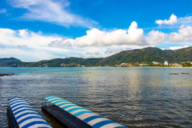 Kathu Phuket Thailand 13. October 2025 Patong Beach bay sea coast panorama view with promenade tourists people turquoise blue water boats mountains and palm trees in Patong Phuket Thailand.