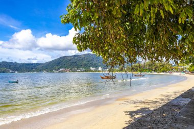 Kathu Phuket Thailand 13. October 2025 Patong Beach bay sea coast panorama view with promenade tourists people turquoise blue water boats mountains and palm trees in Patong Phuket Thailand.