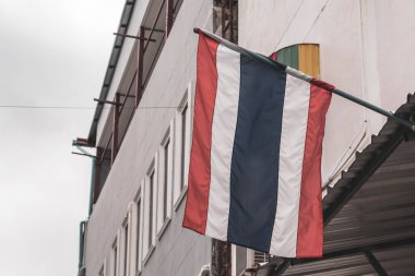 Thai flag blowing in the wind in the city and blue sky in Patong Beach Kathu District Phuket Island Province Southern Thailand in Southeast Asia.