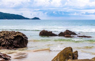 Güneydoğu Asya 'daki Güney Tayland' da Patong Sahili Kathu Bölgesi Phuket Adası Eyaleti 'nde turkuaz mavi su dalgaları ve kayalarla inanılmaz kayalık tropikal manzara manzarası..