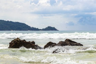 Güneydoğu Asya 'daki Güney Tayland' da Patong Sahili Kathu Bölgesi Phuket Adası Eyaleti 'nde turkuaz mavi su dalgaları ve kayalarla inanılmaz kayalık tropikal manzara manzarası..