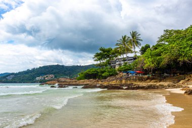 Güneydoğu Asya 'daki Güney Tayland' da Patong Sahili Kathu Bölgesi Phuket Adası Eyaleti 'nde turkuaz mavi su dalgaları palmiye ağaçları ve kayalarla inanılmaz kayalık tropikal manzara manzarası..