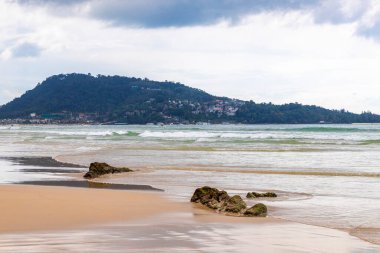 Güneydoğu Asya 'daki Güney Tayland' da Patong Sahili Kathu Bölgesi Phuket Adası Eyaleti 'nde turkuaz mavi su dalgaları ve kayalarla inanılmaz kayalık tropikal manzara manzarası..
