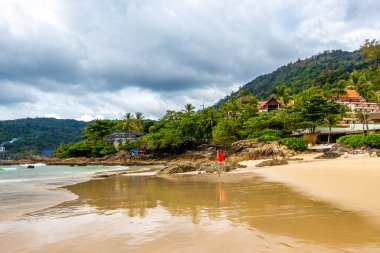 Güneydoğu Asya 'daki Güney Tayland' da Patong Sahili Kathu Bölgesi Phuket Adası Eyaleti 'nde turkuaz mavi su dalgaları palmiye ağaçları ve kayalarla inanılmaz kayalık tropikal manzara manzarası..