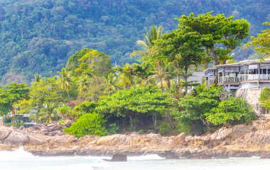 Güneydoğu Asya 'daki Güney Tayland' da Patong Sahili Kathu Bölgesi Phuket Adası Eyaleti 'nde turkuaz mavi su dalgaları palmiye ağaçları ve kayalarla inanılmaz kayalık tropikal manzara manzarası..