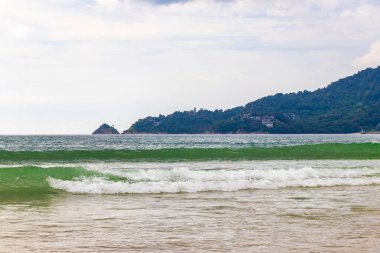 Kathu Phuket Tayland 17 numara. Ekim 2025 Patong Sahili sahil manzaralı gezinti turistleri açık mavi su dalgaları ve yeşil dağlar ve Patong Tayland 'daki palmiye ağaçları..