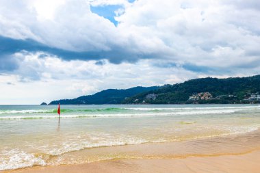 Patong Beach bay sea coast panorama view with turquoise blue clear water waves white sand and green mountains and palm trees in Patong Beach Kathu District Phuket Island Province Southern Thailand.