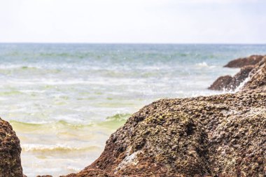 Güneydoğu Asya 'daki Güney Tayland' da Patong Sahili Kathu Bölgesi Phuket Adası Eyaleti 'nde turkuaz mavi su dalgaları ve kayalarla inanılmaz kayalık tropikal manzara manzarası..