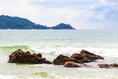 Güneydoğu Asya 'daki Güney Tayland' da Patong Sahili Kathu Bölgesi Phuket Adası Eyaleti 'nde turkuaz mavi su dalgaları ve kayalarla inanılmaz kayalık tropikal manzara manzarası..