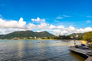 Kathu Phuket Thailand 13. October 2025 Patong Beach bay sea coast panorama view with promenade tourists people turquoise blue water boats mountains and palm trees in Patong Phuket Thailand.