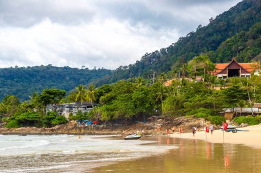 Kathu Phuket Tayland 17 numara. Ekim 2025 Patong Sahili sahil manzaralı gezinti turistleri açık mavi su dalgaları ve yeşil dağlar ve Patong Tayland 'daki palmiye ağaçları..