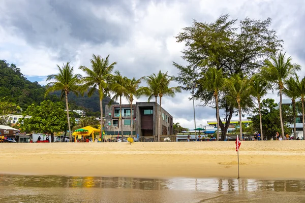 Kathu Phuket Tayland 17 numara. Ekim 2025 Patong Sahili manzaralı gezinti turistleri mavi su dalgaları güneş şemsiyeleri cankurtaran kuleleri dağlar ve Tayland palmiyeleri.