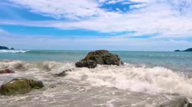 İnanılmaz kayalık Kalim Sahili tropikal manzara manzarası mavi gökyüzü turkuvaz su dalgaları ve kayalar ile Patong Sahili Kathu Bölgesi Phuket Adası Güney Tayland.