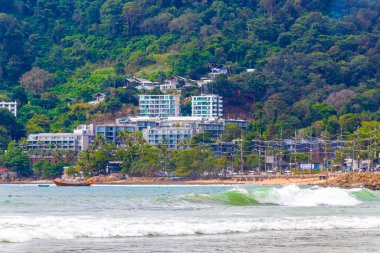 Kalim Sahili sahili deniz manzarası turkuvaz mavisi berrak su dalgaları beyaz kum ve yeşil dağlar ve Patong Sahili 'ndeki palmiye ağaçları Kathu Phuket Adası Güney Tayland.