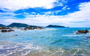 İnanılmaz kayalık Kalim Sahili tropikal manzara manzarası mavi gökyüzü turkuvaz su dalgaları ve kayalar ile Patong Sahili Kathu Bölgesi Phuket Adası Güney Tayland.