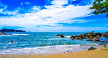 İnanılmaz kayalık Kalim Sahili tropikal manzara manzarası mavi gökyüzü turkuvaz su dalgaları ve kayalar ile Patong Sahili Kathu Bölgesi Phuket Adası Güney Tayland.