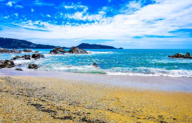 İnanılmaz kayalık Kalim Sahili tropikal manzara manzarası mavi gökyüzü turkuvaz su dalgaları ve kayalar ile Patong Sahili Kathu Bölgesi Phuket Adası Güney Tayland.