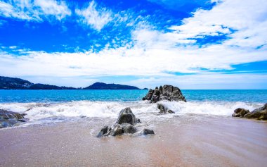İnanılmaz kayalık Kalim Sahili tropikal manzara manzarası mavi gökyüzü turkuvaz su dalgaları ve kayalar ile Patong Sahili Kathu Bölgesi Phuket Adası Güney Tayland.