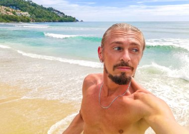 Güneydoğu Asya 'daki Güney Tayland' da Patong Sahili Kathu Bölgesi Phuket Adası Eyaleti 'nde turkuaz mavi su kayaları ve beyaz kumla tropik Kalim Sahili' nde seksi yakışıklı turist..