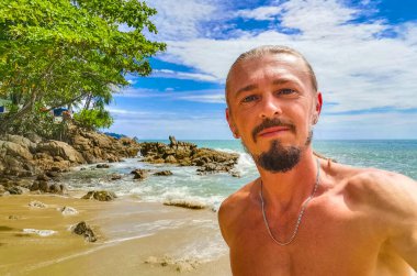 Güneydoğu Asya 'daki Güney Tayland' da Patong Sahili Kathu Bölgesi Phuket Adası Eyaleti 'nde turkuaz mavi su kayaları ve beyaz kumla tropik Kalim Sahili' nde seksi yakışıklı turist..