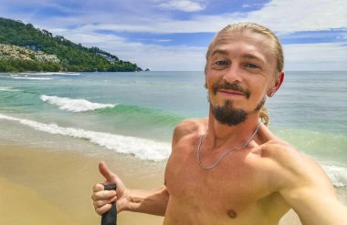 Güneydoğu Asya 'daki Güney Tayland' da Patong Sahili Kathu Bölgesi Phuket Adası Eyaleti 'nde turkuaz mavi su kayaları ve beyaz kumla tropik Kalim Sahili' nde seksi yakışıklı turist..