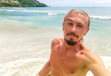 Güneydoğu Asya 'daki Güney Tayland' da Patong Sahili Kathu Bölgesi Phuket Adası Eyaleti 'nde turkuaz mavi su kayaları ve beyaz kumla tropik Kalim Sahili' nde seksi yakışıklı turist..