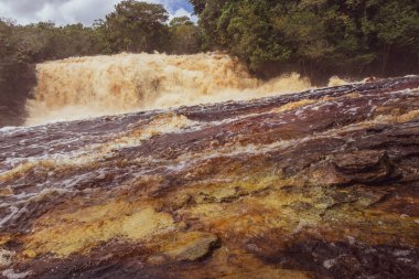 Kızıl nehir suyu ve şelale Cachoeira Sucuriju turuncu sarı kahverengi renkler tropikal orman doğasında doğa ve Brezilya 'nın Amazon eyaletinde yağmur ormanları.