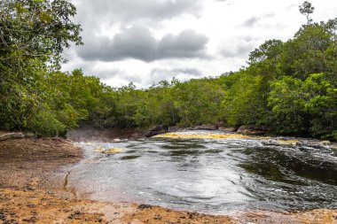 Kızıl nehir suyu ve şelale Cachoeira Sucuriju turuncu sarı kahverengi renkler tropikal orman doğasında doğa ve Brezilya 'nın Amazon eyaletinde yağmur ormanları.