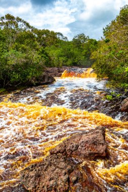 Kızıl nehir suyu ve şelale Cachoeira Sucuriju turuncu sarı kahverengi renkler tropikal orman doğasında doğa ve Brezilya 'nın Amazon eyaletinde yağmur ormanları.