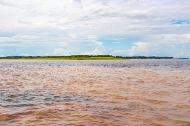 Rio Negro 'nun karasu suyu Amazon Nehri' nin beyaz suyu ve tropikal orman yağmur ormanı ve Iranduba Manaus Manaus Brezilya 'da mavi bulutlu gökyüzü ile tekne turu..