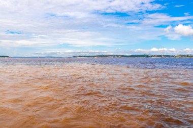 Rio Negro 'nun karasu suyu Amazon Nehri' nin beyaz suyu ve tropikal orman yağmur ormanı ve Iranduba Manaus Manaus Brezilya 'da mavi bulutlu gökyüzü ile tekne turu..