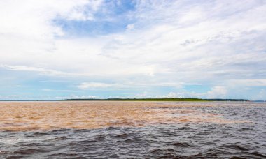 Rio Negro 'nun karasu suyu Amazon Nehri' nin beyaz suyu ve tropikal orman yağmur ormanı ve Iranduba Manaus Manaus Brezilya 'da mavi bulutlu gökyüzü ile tekne turu..