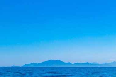 Rio de Janeiro Brezilya 'nın Angra dos Reis eyaletinde turkuvaz yeşili ve berrak su kayaları ve mavi gökyüzü ile tropik adalar adası sahili manzarası..