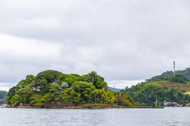 Rio de Janeiro Brezilya 'nın Angra dos Reis eyaletinde turkuvaz yeşili ve berrak su kayaları ve mavi gökyüzü ile tropik adalar adası sahili manzarası..